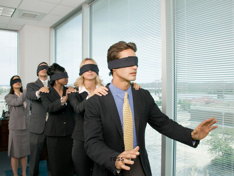 new leader not knowing where to go a leader with a blindfold leading other people with blindfolds